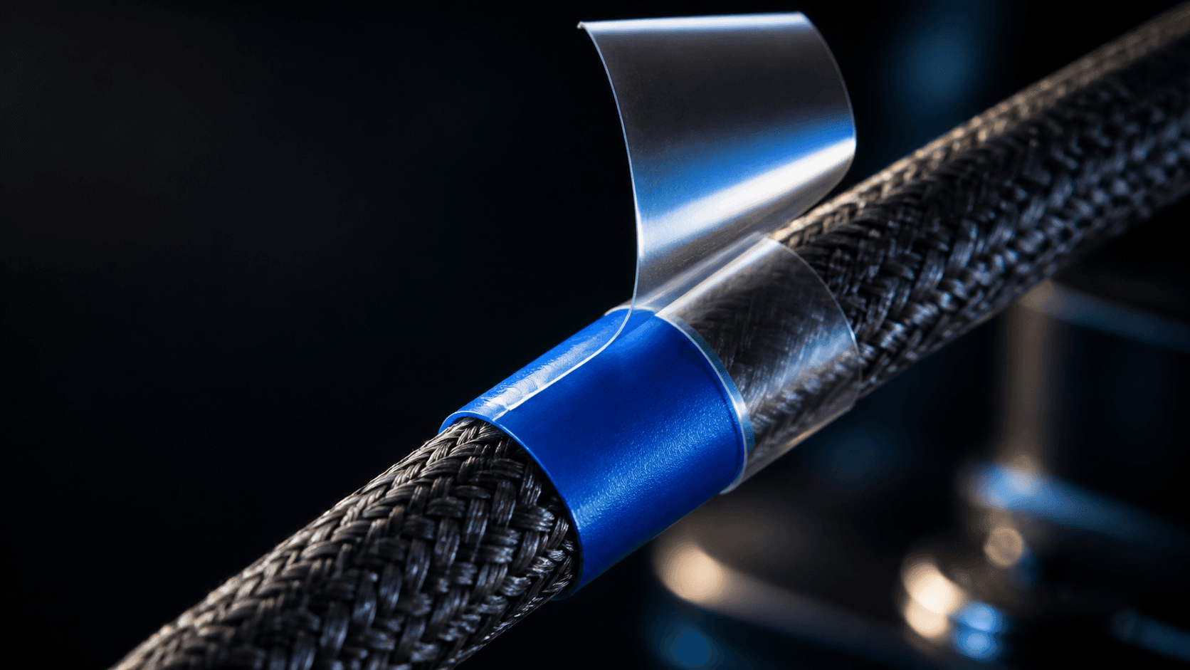 Macro view of a colored cable identification wrap protected by a continuous clear sealing wrap